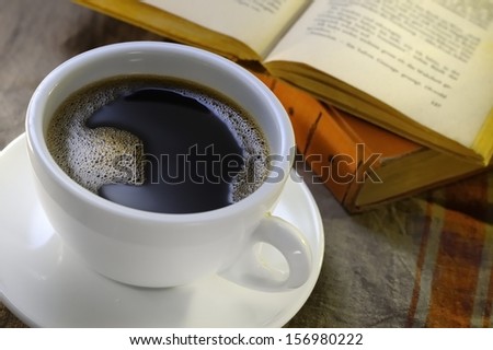 Cup of coffee with old books in the background