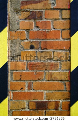 background texture, old brickwall with black and yellow steel joints on either side