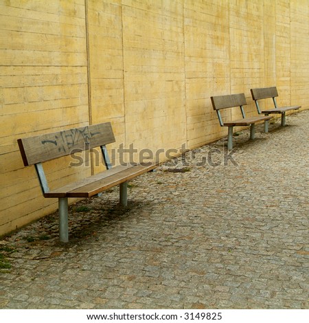 three benches in front of concrete wall