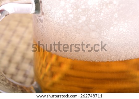 Glass of fresh beer with cap of foam