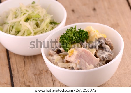 Cabbage salad and meat salad with green parsley on wooden plate, health food concept