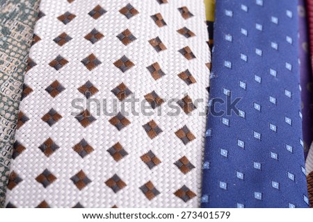 Set of rolled up silk ties close to each other, side-by-side