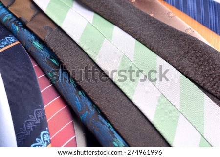 Set of rolled up silk ties close to each other, side-by-side