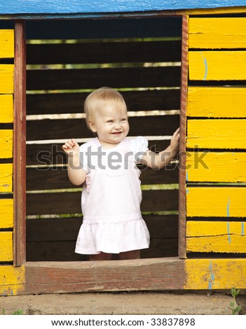 The little happy girl in rose dress. Playing in little house