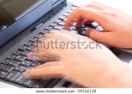 Hands typing on a laptop computer keyboard