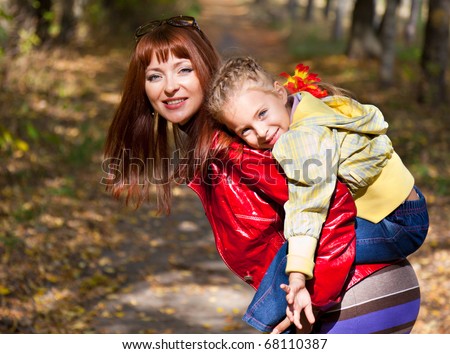 a ginger-head woman is holding her child on her back