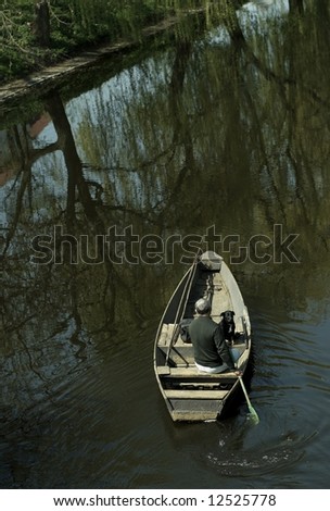 Man and dog  in boat on river.