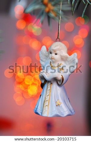 Christmas ball - angel on tree and Xmas light background.