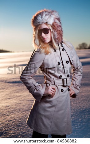 Beautiful Teenage Girl in  Winter Coat and Fury Hat on Snow