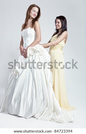 and Bridesmaid on neutral background in white and yellow wedding dress