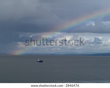 Stormy sky with rainbow and fishing boat