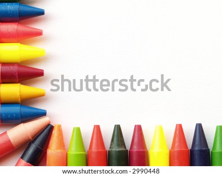 Wax crayons arranged as border on two sides of paper