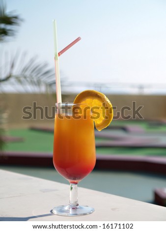 Glass of tequila sunrise on a marble wall