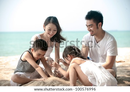 Happy Asian Family Playing on the beach
