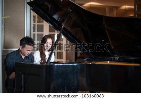 Asian Couple playing the grand piano