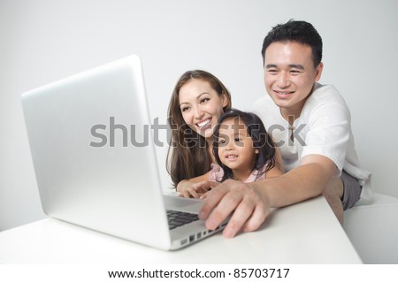 Asian family using the laptop with the daughter
