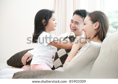 Happy Asian Family Playing With Daughter In The Living Room
