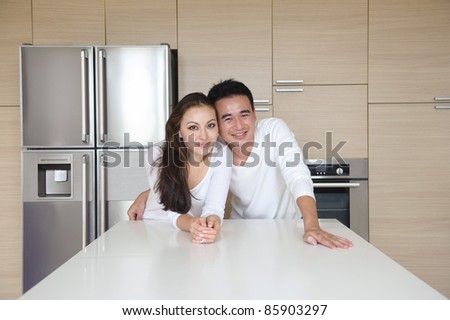 Attractive Asian Couple standing close to each other in the kitchen