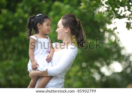 Asian mum and daughter enjoying each others company in the park