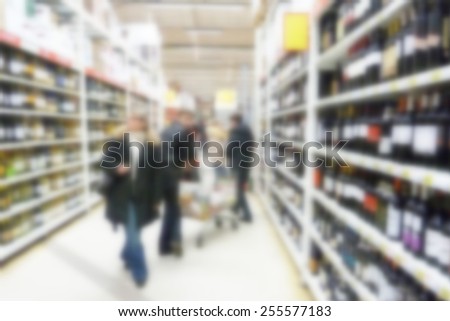 Buyers in the wine department of supermarket.Specially blurred photo