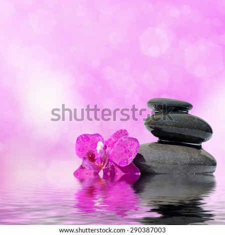 Zen spa concept background - Zen massage stones and orchid flowers reflected in water