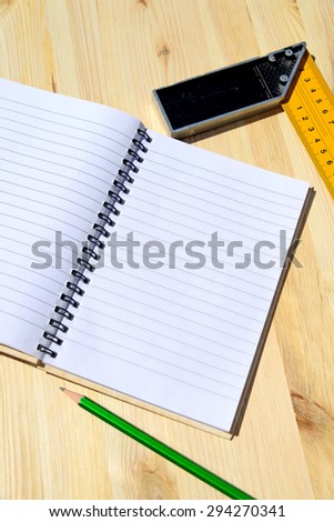 Workplace and tools of a carpenter or builder-open notebook,ruler and pencil lie on the working surface