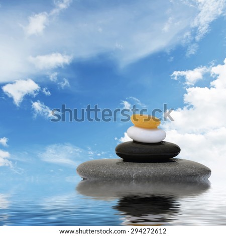 Zen spa concept background-Zen massage stones and orchid flowers reflected in water