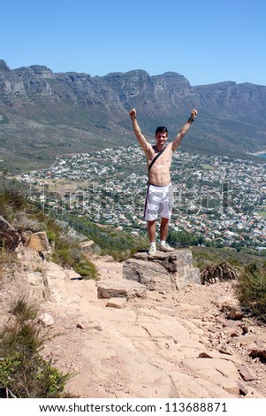 Man celebrating on lions head, cape town, south africa
