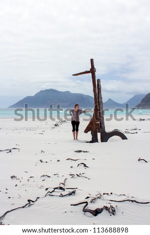 Woman standing at Shipwreck Kakapo at the beach of kommetjie with upcoming storm in the background