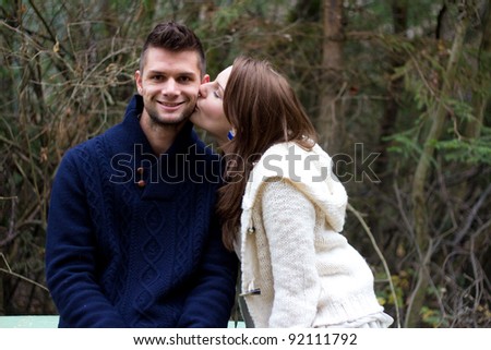 Young couple holding hands in the forest in front of trees