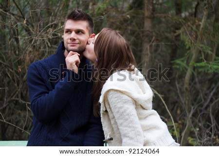 Young couple holding hands in the forest in front of trees