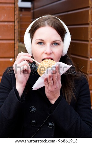 Young Brunette Woman Eating A Glazed Apple For Dessert During Winter