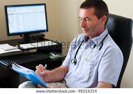 Doctor Writing On A Document In He\'s Practice