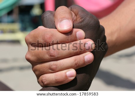 A black and a white person shake hands