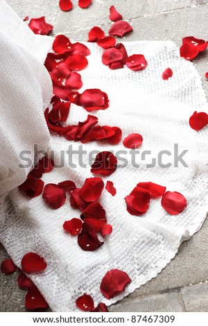 stock photo Red rose pedals on a white wedding dress