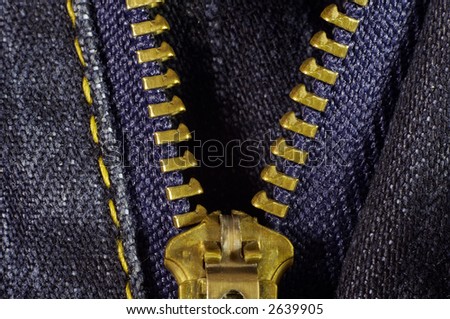 Blue jeans and gold zipper. Macro shot.