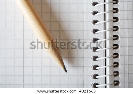 Wooden pencil on spiral bound notebook closeup. Space for text.