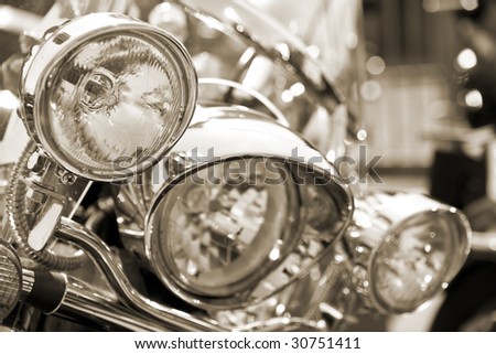 View of motorbike front head lamps. Sepia tone. Shallow DOF.