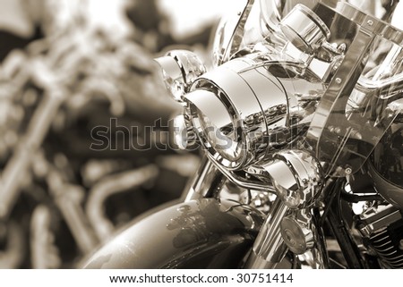 View of motorbike front head lamps. Sepia tone. Shallow DOF.