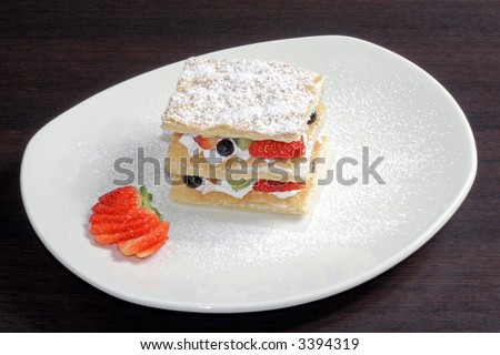 fruit cake with strawberry, kiwi, blueberry in the white plate