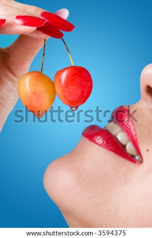 Close up of a sweet cherry and female lips