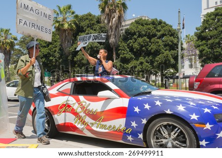 Los Angeles, CA, USA - April 14, 2015:  People holding sign next to a car painted in american flag colors during Stop Murder by Police.