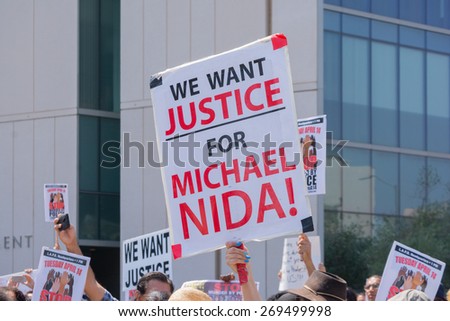 Los Angeles, CA, USA - April 14, 2015:  People raising signs for justice during Stop Murder by Police. Protest against the brutalization and murdering of black and latino people by police.