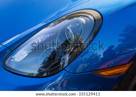 Close-up view of blue sports car headlight on display