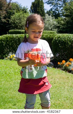 little girl having fun with making soap bubbles