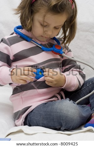 little doctor. 4 years old girl playing with stethoscope