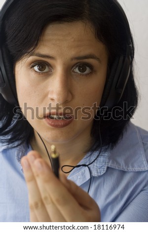 portrait of an young woman with headphones and jack plug in hand