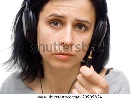 portrait of an young woman with headphones and jack plug in hand