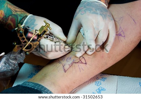 man wearing gloves and making a tattoo