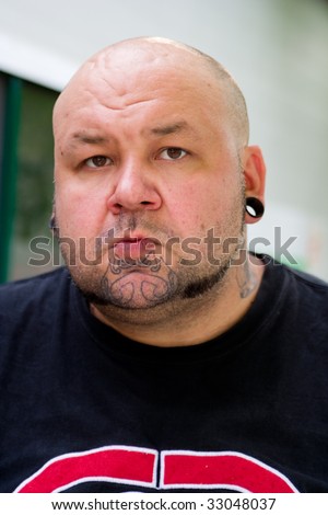 portrait of a man with tattoo on his face